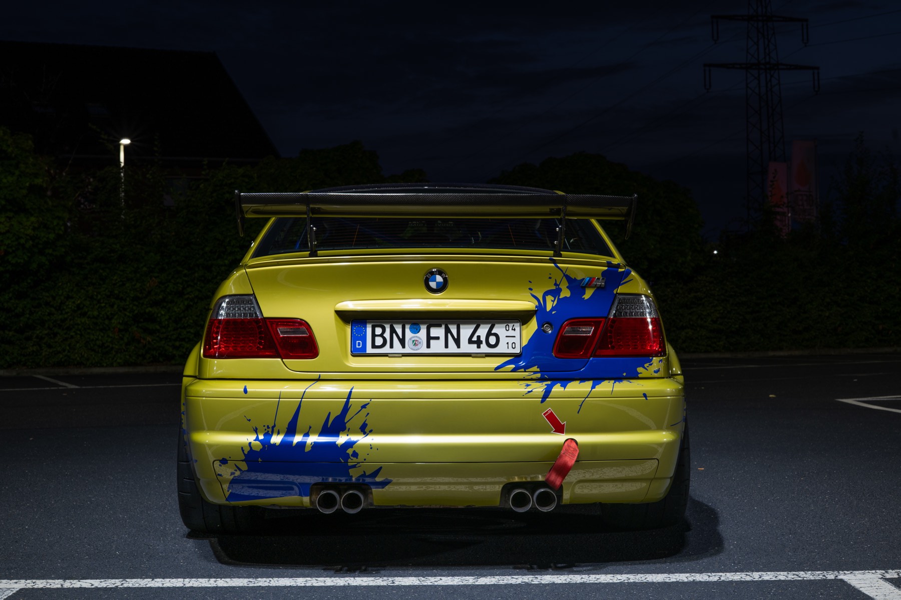 Heck eines BMW E46 M3 in gelber Lackierung in der Dämmerung